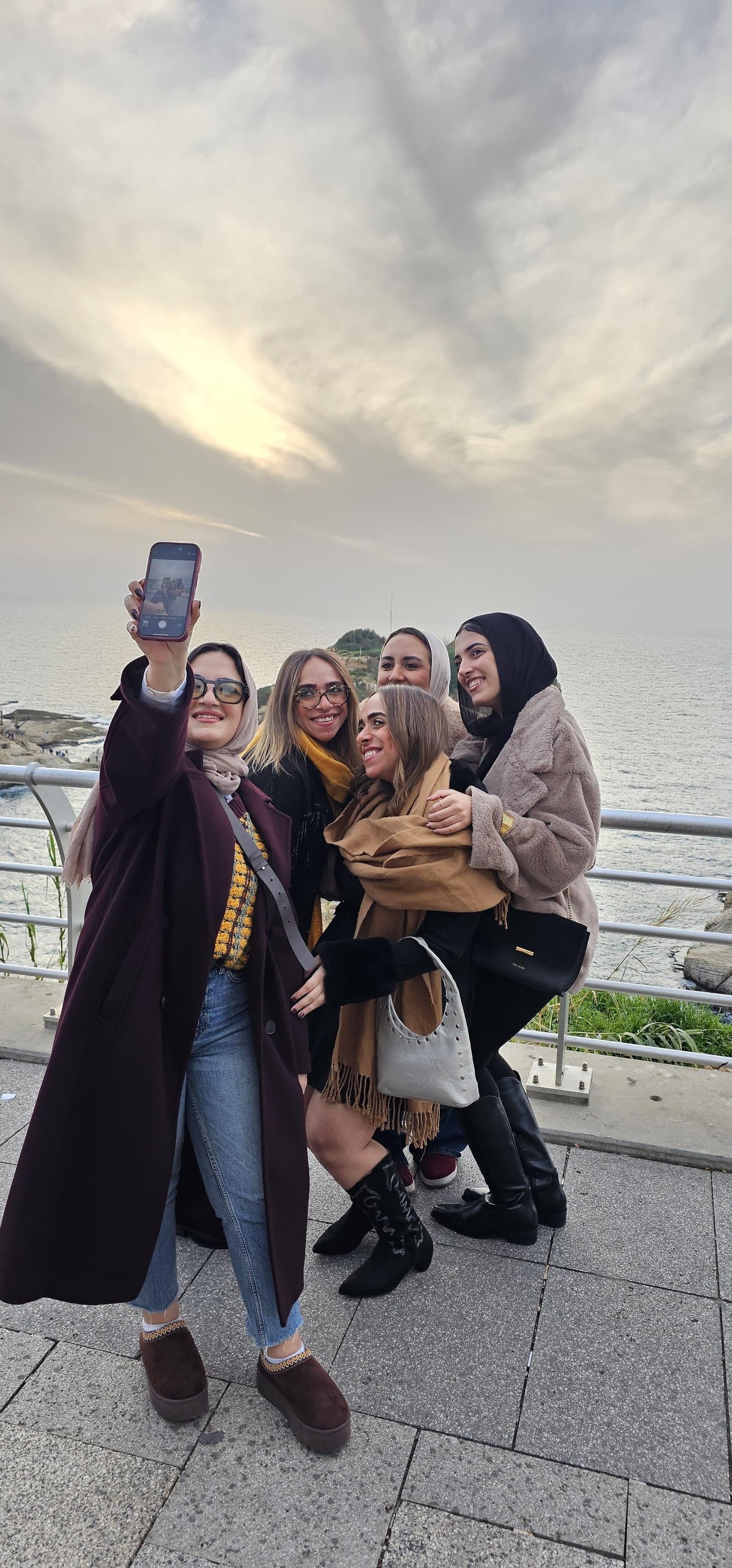 مسافرات في صورة تذكارية على البحر